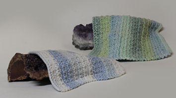 two rocks covered in crocheted blankets